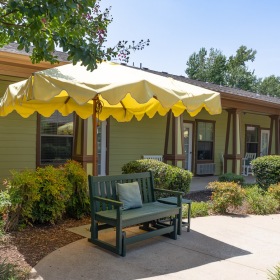 A beautiful community at the heart of all your passions an outdoor sitting area under an umbrella